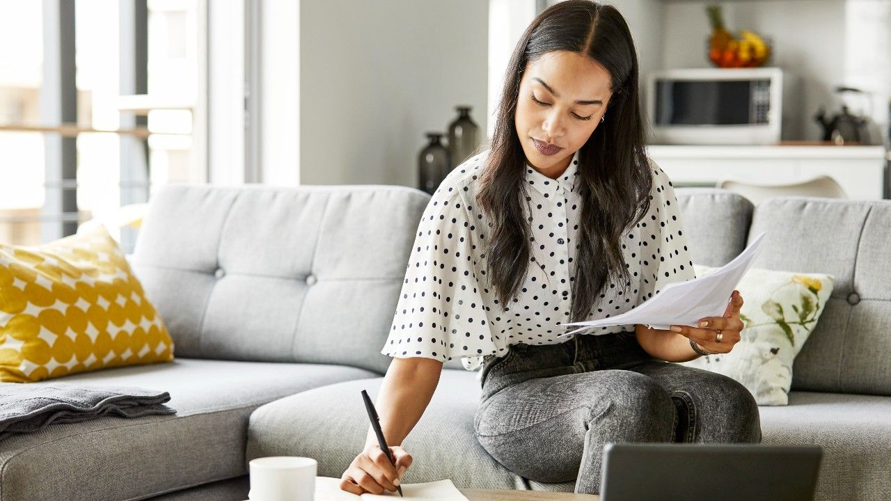 working woman writing with a pen on a piece of paper at home