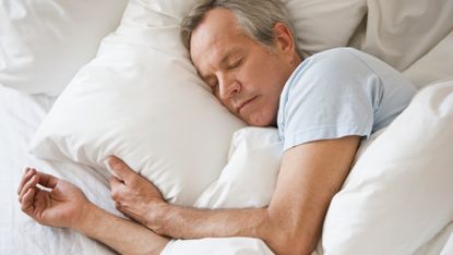 Older man sleeps soundly in his bed