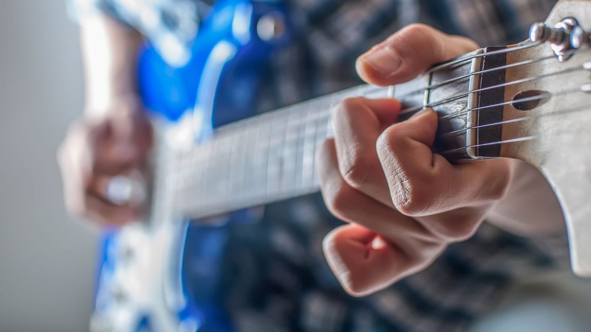 Close up of man&#039;s fingers playing electric guitar