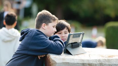Two ACS pupils look at a tablet