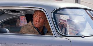 Daniel Craig glaring out of his driver's side window in No Time To Die.