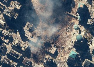 Space Imaging's IKONOS satellite collected this image of Manhattan, New York at 11:54 a.m. EDT on Sept. 15, 2001. The image shows the remains of the 1,350-foot towers of the World Trade Center, and the debris and dust that settled throughout the area. Also visible are many emergency and rescue vehicles in the streets. IKONOS orbits 423 miles above the Earth's surface at a speed of 17,500 miles per hour.