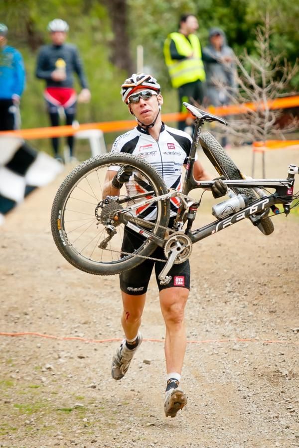 Thomas Litscher walks to the finish with his destroyed bike following a crash just before the start