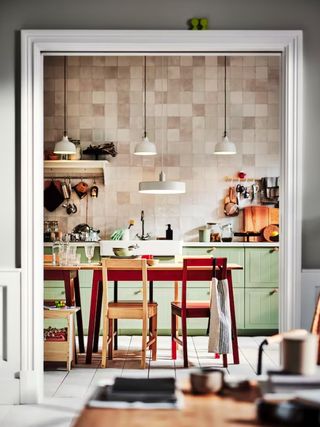 IKEA kitchen with green cabinets and tiled wall
