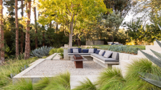 a sunken seating area with a firepit in a beautiful, lush garden 