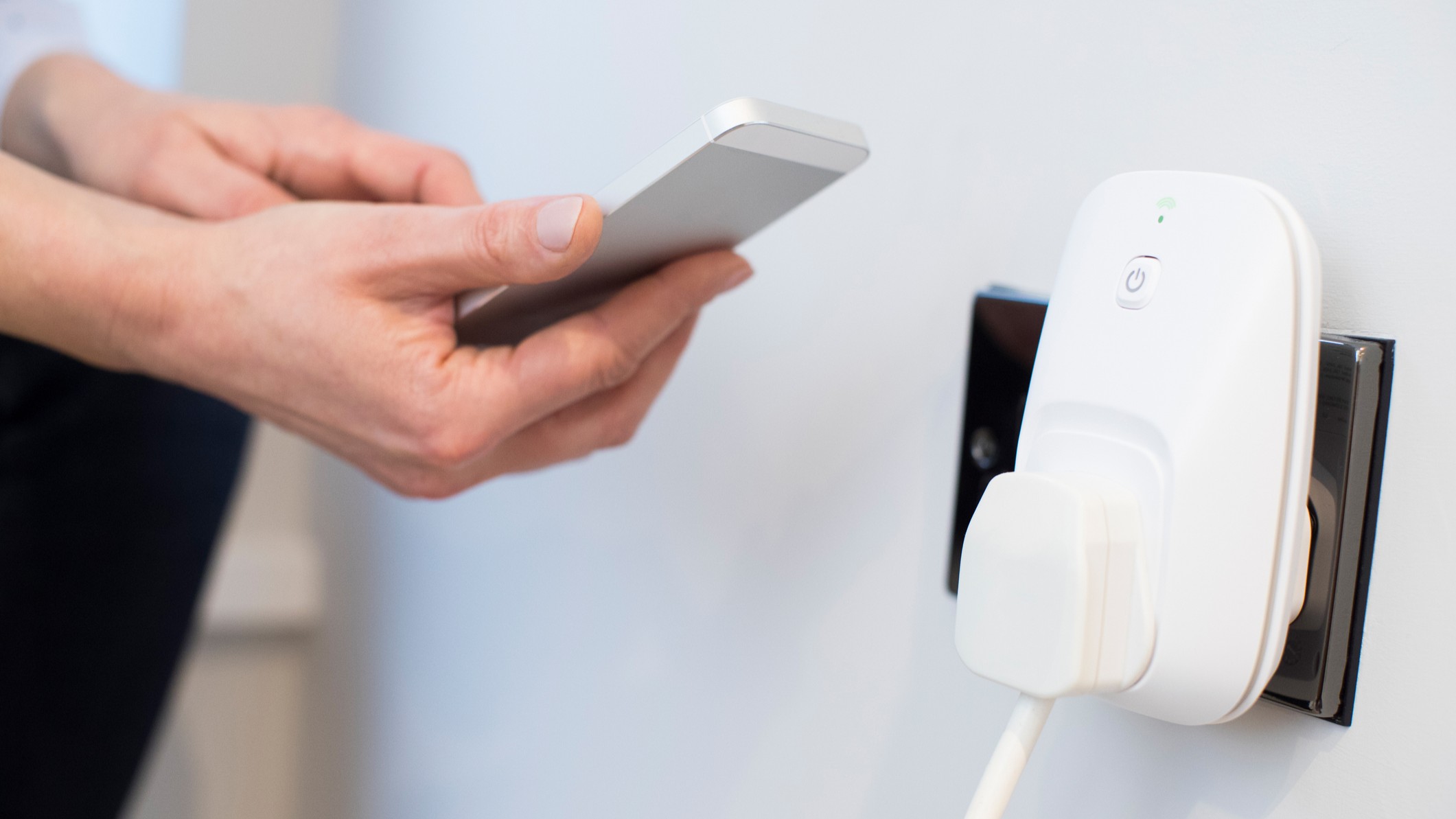 Person using phone to operate smart plug