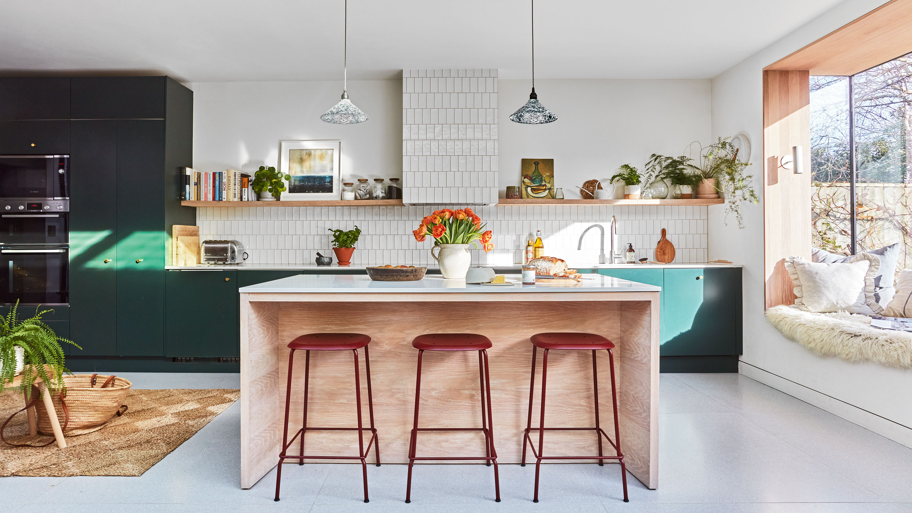 White and green kitchen with wooden kitchen island and red kitchen bar stools