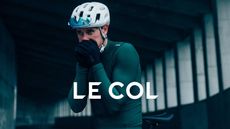 Rider blowing in his hands while wearing Le Col apparel and Le Col overlay logo