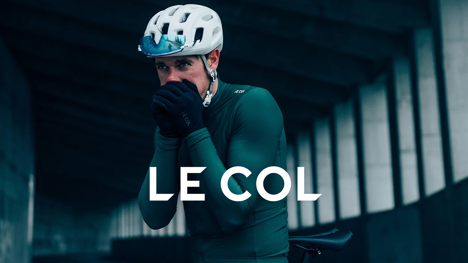 Rider blowing in his hands while wearing Le Col apparel and Le Col overlay logo