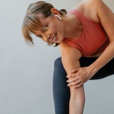 A woman doing rotational exercises on her balcony in gym gear
