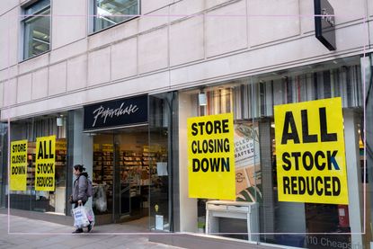 a close up of a Paperchase store with closing down posters displayed in windows