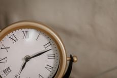 analog clock with gold frame and a beige background