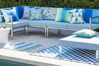blue decorative outdoor rugs in garden setting with white and blue outdoor furniture