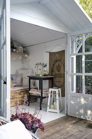 garden shed turned into a cosy garden hideaway with lanterns and seating