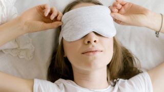 Woman using a sleep mask, sleep & wellness tips