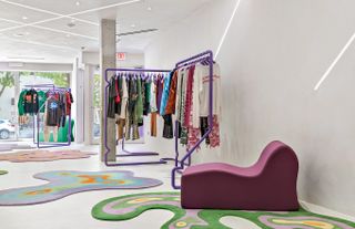 The colorfully decorated, funky interiors of a concept store feature flower-shaped rugs and whimsical armchairs.