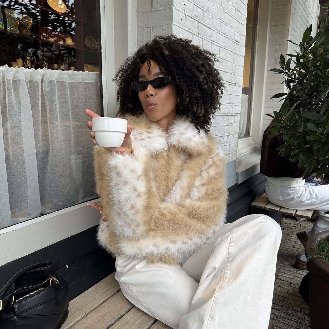 Influencer holding coffee mug outside