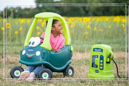 An image of a little girl sitting in the Little Tikes Cozy Coupe ride-in car which has had an electric makeover