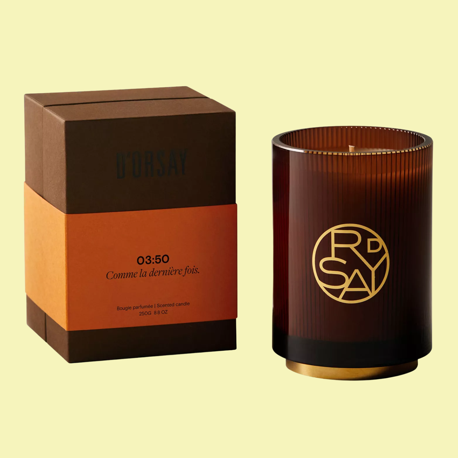 A scented candle in a brown ribbed glass