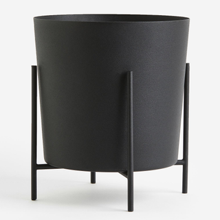 A black planter with a stand