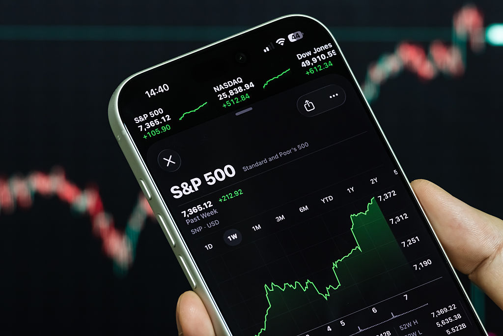 smartphone displays the S&amp;P 500 index and U.S. stock market data in front of a stock chart background on May 7, 2026