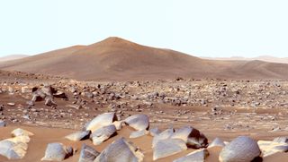 Bluish rocks in the foreground against a reddish terrain