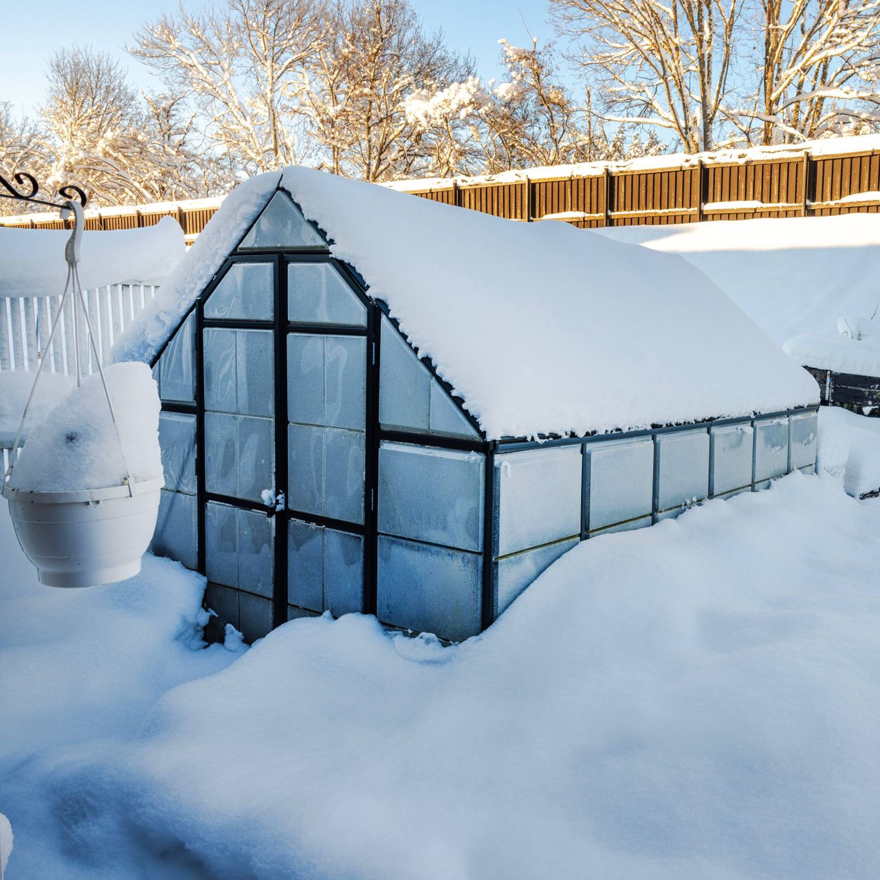 A greenhouse surrounded by deep snow