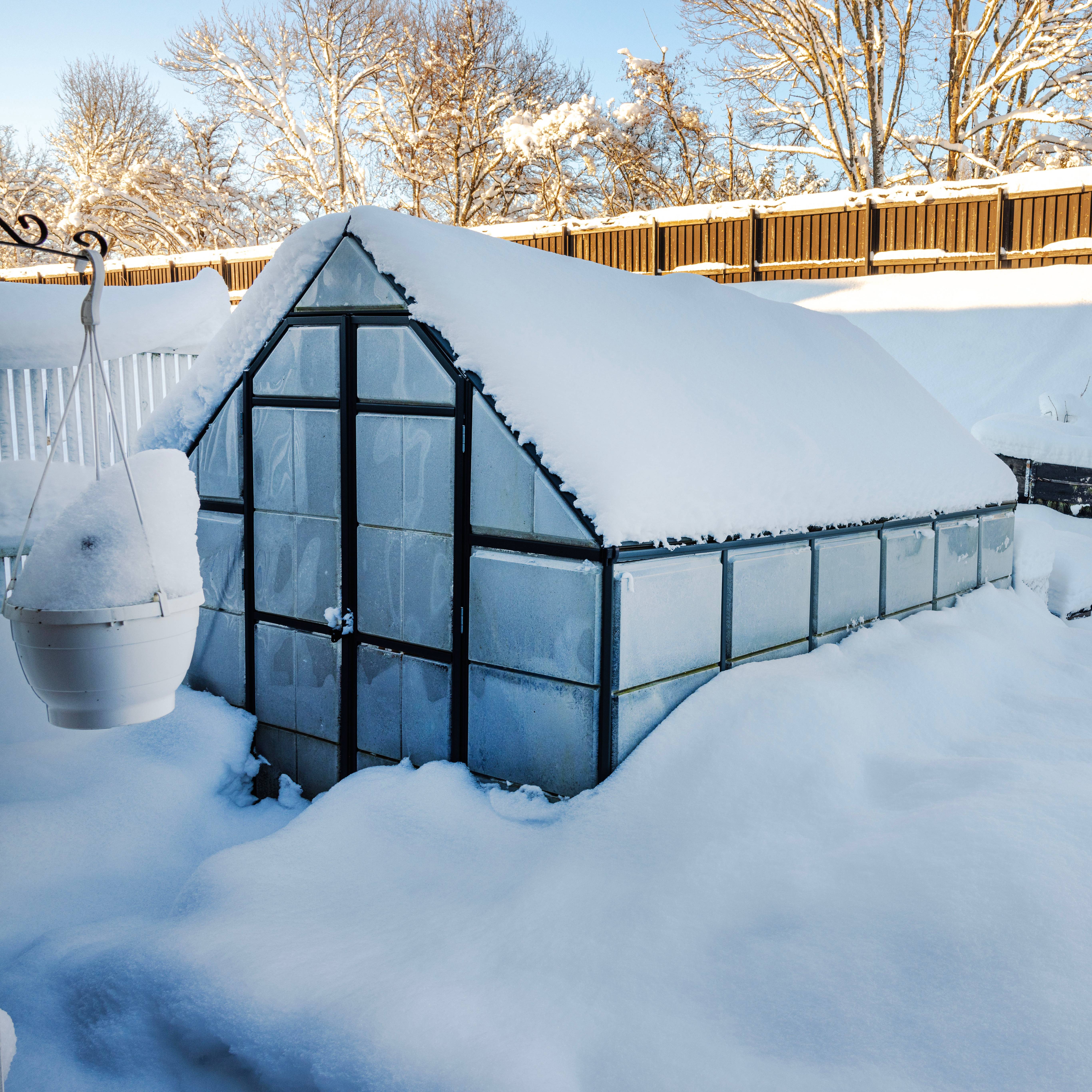 A greenhouse surrounded by deep snow