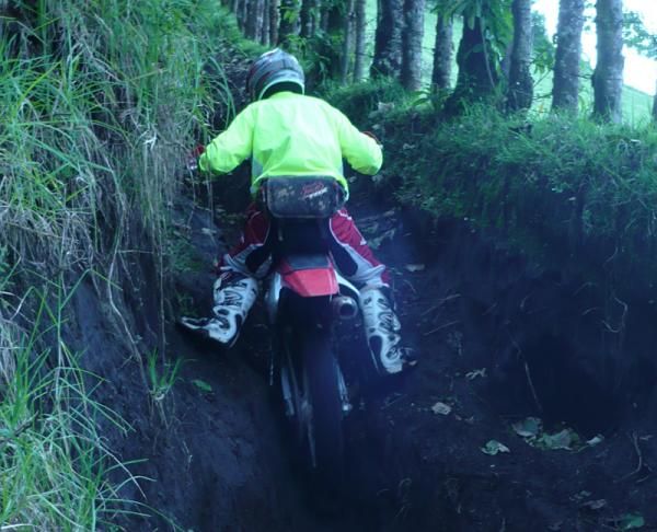 A moto negotiates a singletrack that is more like a trench.