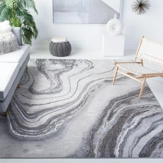 A marble effect rug in a white room, next to a white couch