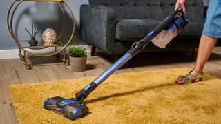 The Shark Anti Hair Wrap Cordless Vacuum cleaning a rug