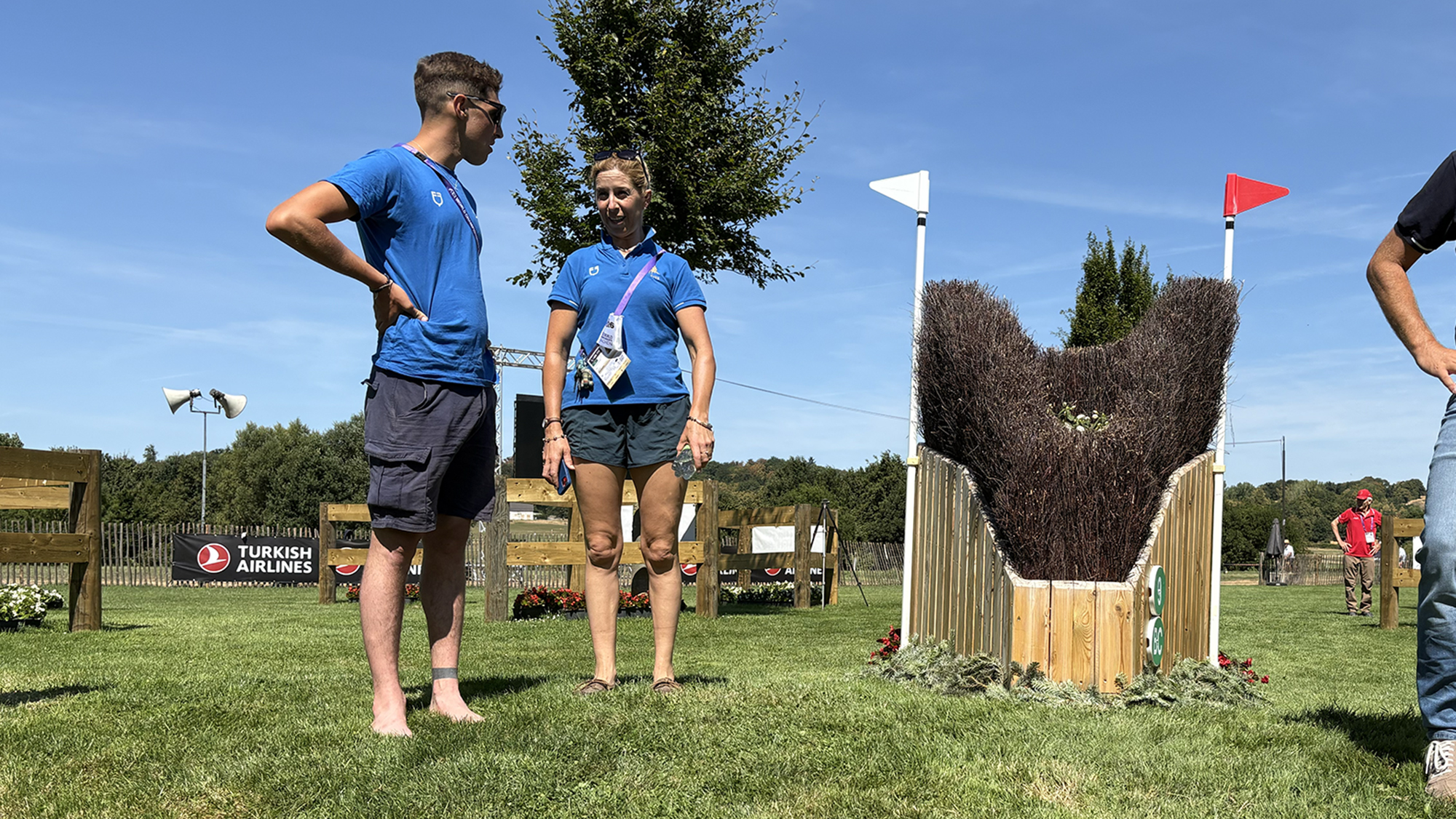 Two members of the Italian squad chat by a narrow fence on the eventing World Championships cross-country course