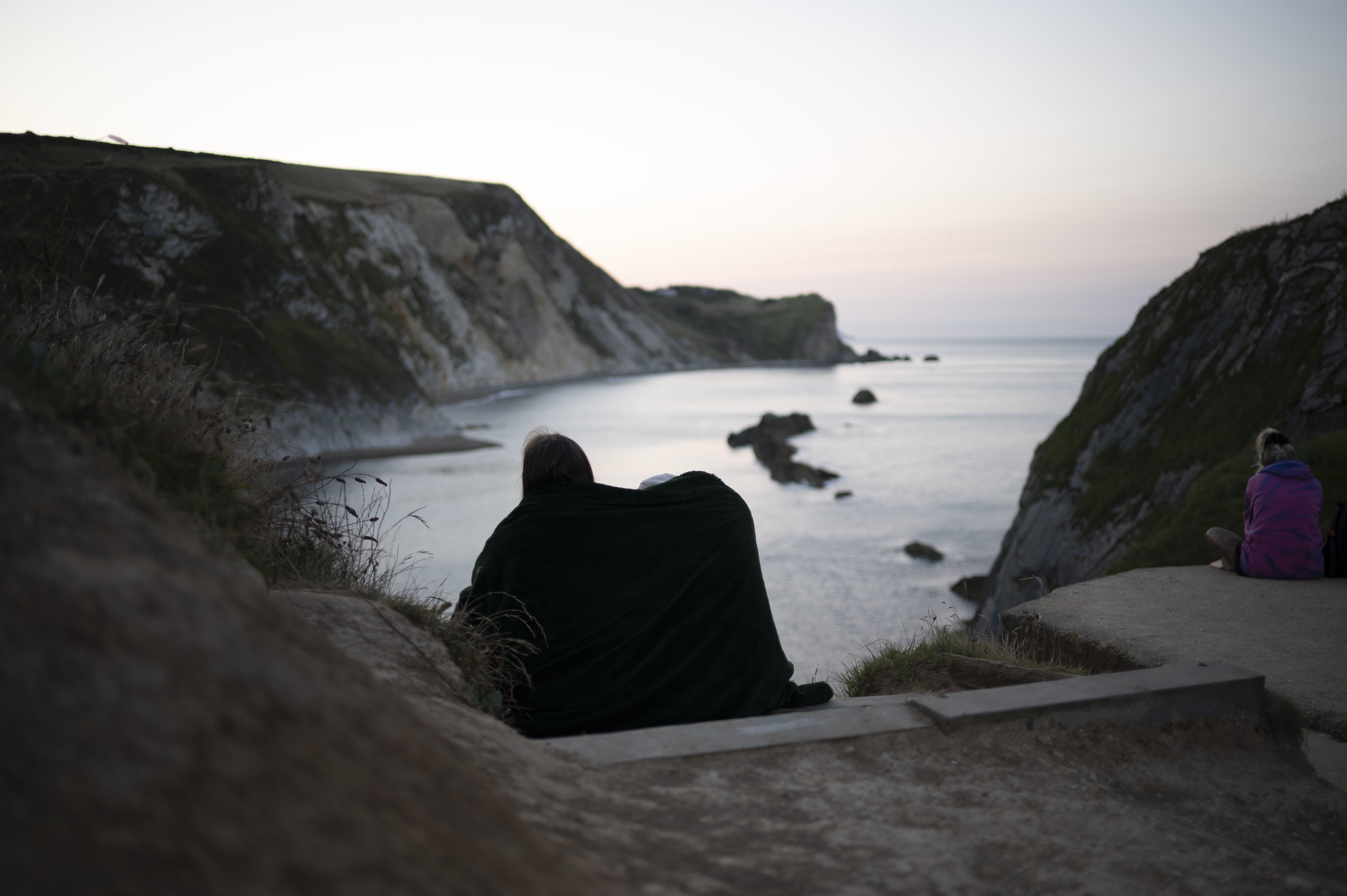 A couple cuddling up watching the sunrise over the ocean, taken with the Nikon Z 35mm f/1.4 lens