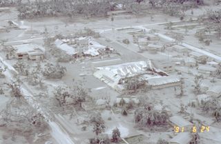 Aerial view of part of Clark Air Base showing buildings and vegetation damaged by tephra (ash) fall from the June 15 eruption of Pinatubo. The photo was taken on June 24, 1991.