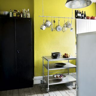 kitchen area with yellow wall and wooden floor and trolley