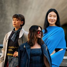 three women with brunette hair and stylish outfits