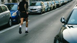 Athlete with tattoos wunnig on the street wearing the CTM Ultra Carbon Race Rebel shoes