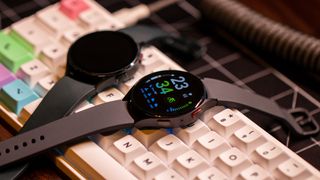 Samsung Galaxy Watch 5 vs Galaxy Watch 4 both screens on angled atop keyboard