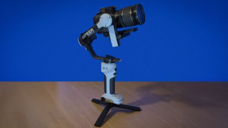 Mini tripod legs are attached to the base of the gimbal so that it stands hands-free