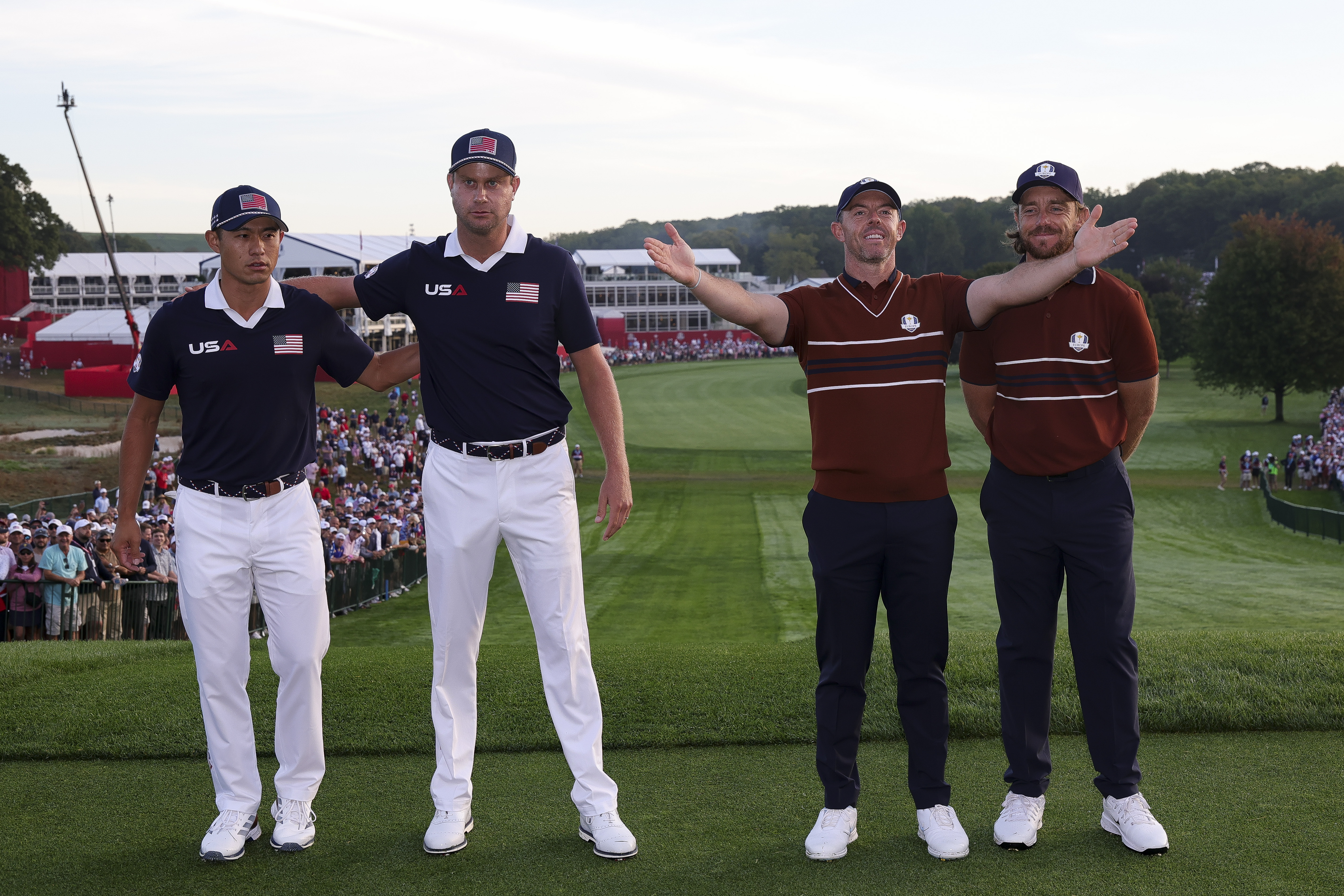 (L to R) Collin Morikawa and Harris English stand arm-in-arm while Rory McIlroy holds his arms aloft to the crowd while Shane Lowry smiles