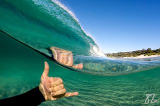 The shaka sign can be seen over and under this peeling wave near Monterey, California.