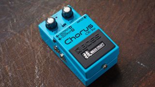 A Boss CE-2W chorus pedal on a scratched wooden floor