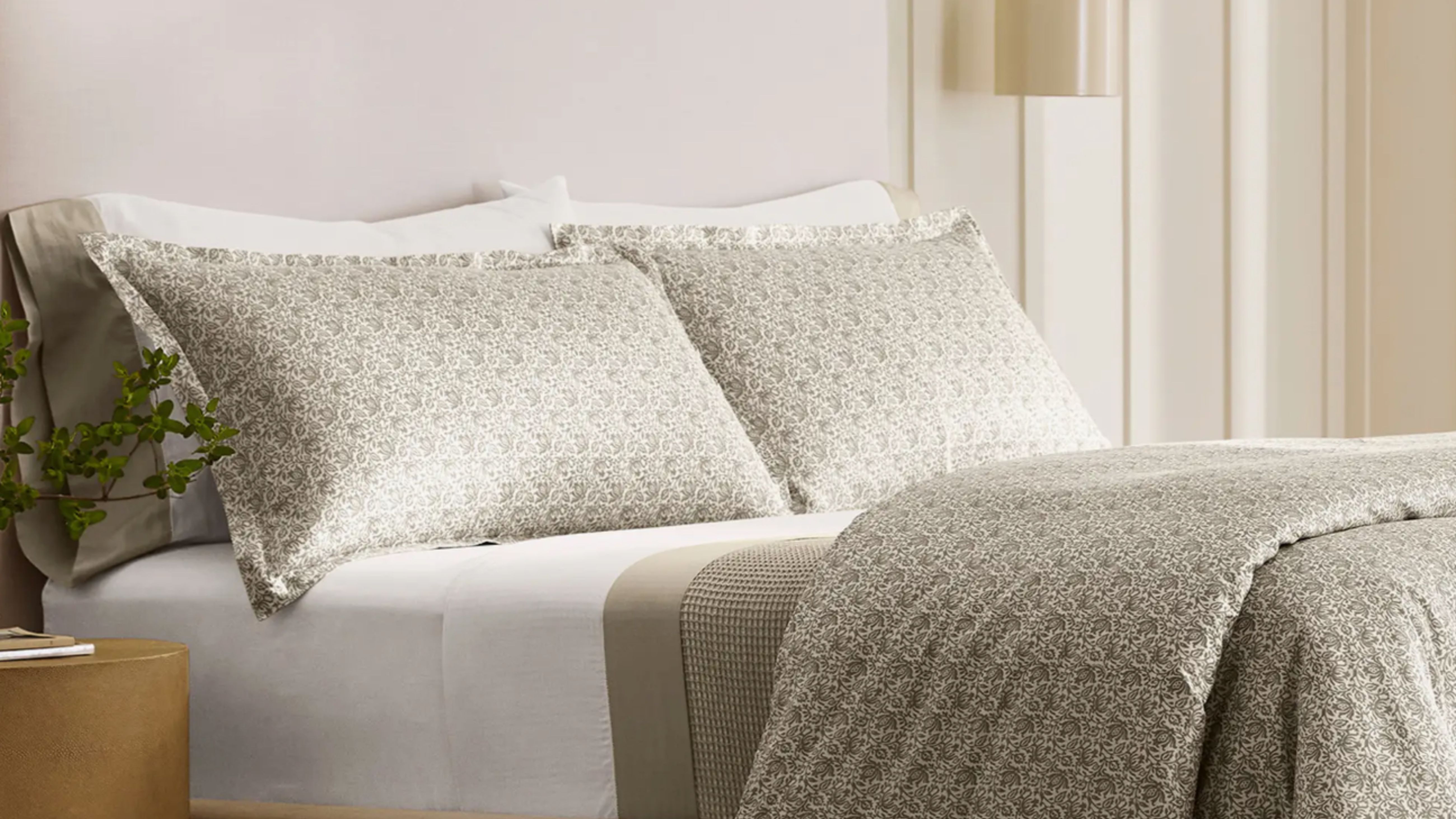 Green and white floral Boll &amp; Branch bedding set photographed in an airy, sunlit bedroom