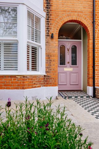 Edwardian house front with black and white front path and pink front door