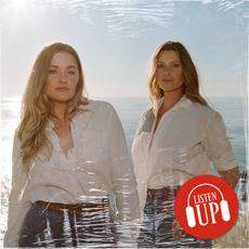 aly and aj michalka wearing white shirts and jeans standing by the ocean 