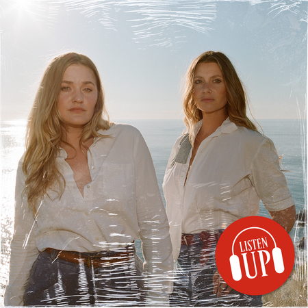 aly and aj michalka wearing white shirts and jeans standing by the ocean 