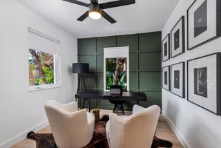 A home office with wall panelling painted green