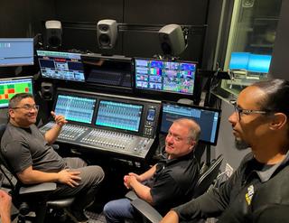 Space City Home Network crew in front of a SSL mixing board.