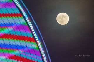 super blue moon shines in top right corner with a colorful blue of light from the ferris wheel in the lower left corner.