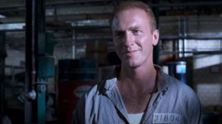 Mark Rolston smiles menacingly in the store room in The Shawshank Redemption.